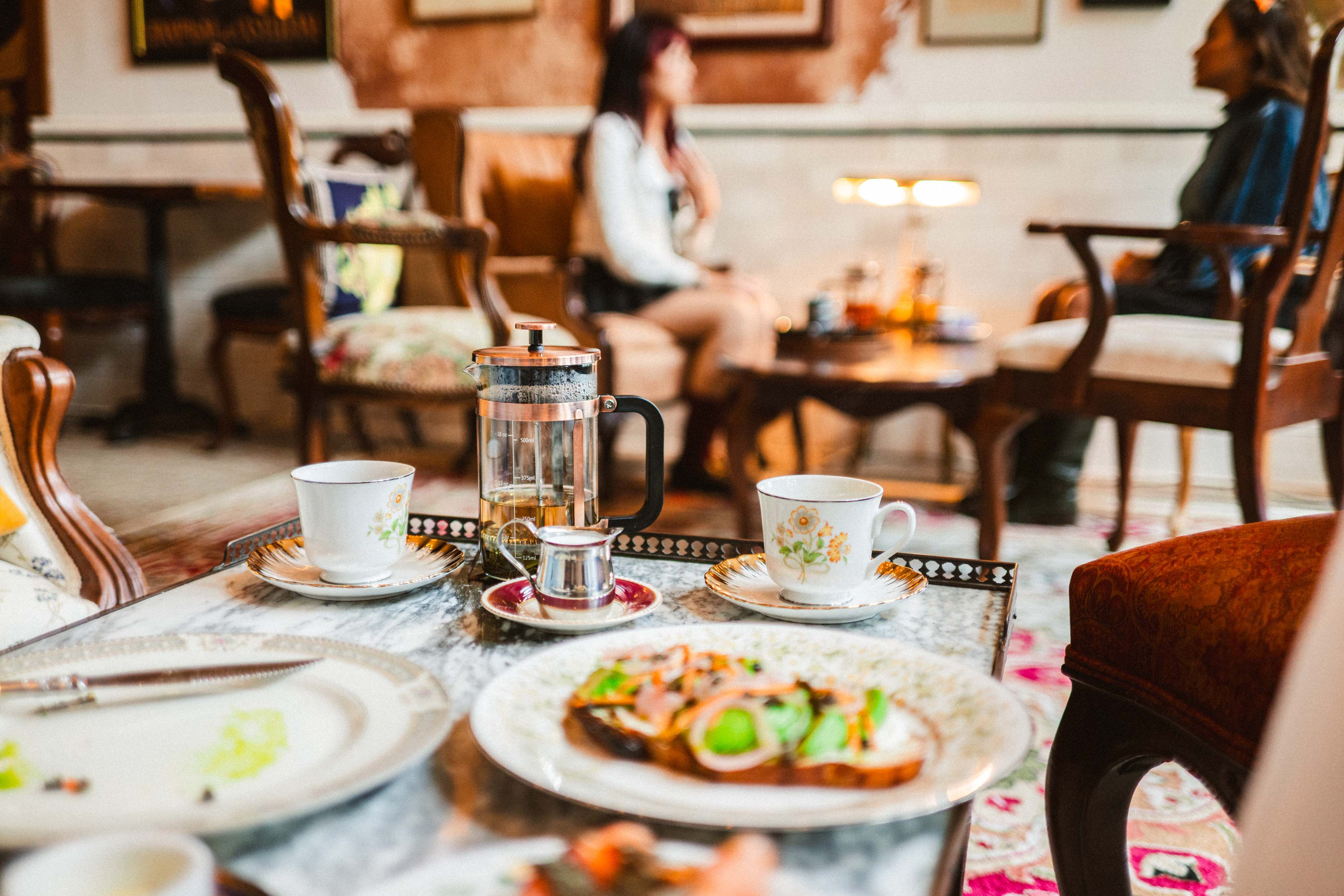 Cafe table with French press and vintage teacups